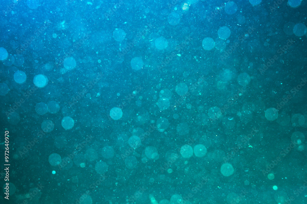 Abstract water background with blue glow. Chaotically moving glowing dust particles in water. Gradient colors. Water torrent isolated. Underwater. Macro world. Textured. Space effect. Wallpaper Abstract water background with blue glow. Chaotically moving glowing dust particles in water. Gradient colors. Water torrent isolated. Underwater. Macro world. Textured. Space effect. Wallpaper
