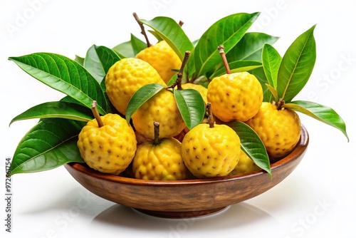 Ripe yellow sitafal fruit with vibrant green leaves and stems, arranged in a decorative bowl, against a soft photo