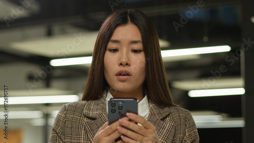 Sad frustrated frown failure stressed upset Asian woman business worker user Japanese student girl looking mobile phone bad news problem lost smartphone Korean businesswoman Chinese female in office photo