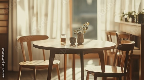 A small, round dining table with a retractable leaf, surrounded by minimalist wooden chairs