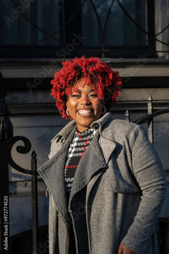 Autumn style fashion clothes worn by beautiful plus size afro Caribbean lady. Model enjoys sun during fall in urban Dutch city Den Haag vibes. Attractive confidence oozes from strong image photo