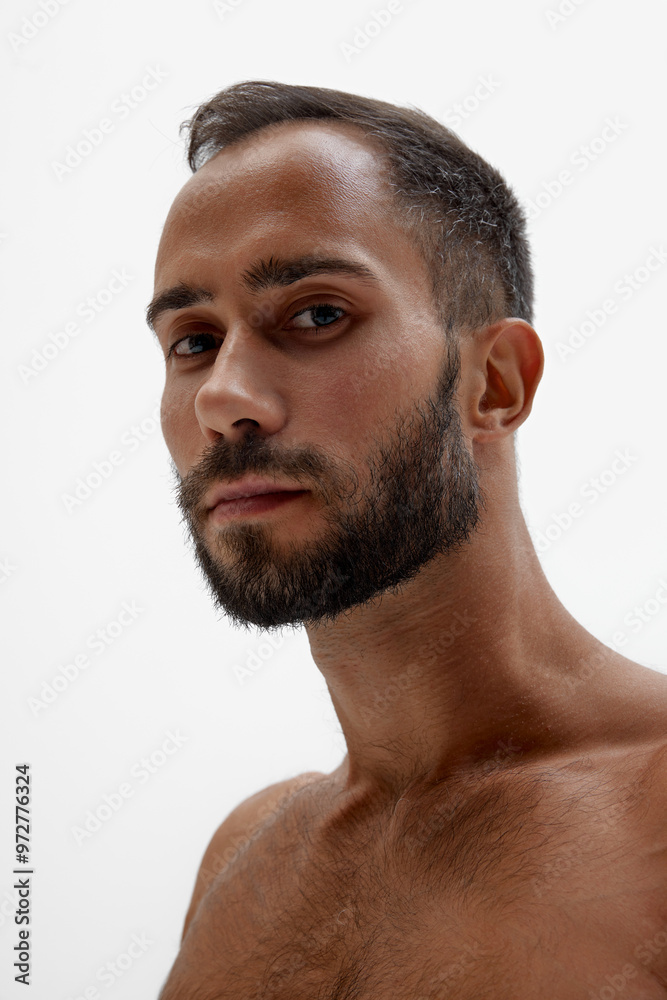Obraz premium Close up photo of bearded man with thoughtful expression looking at camera against white background. Concept of beauty and fashion, style and youth, male health. Ad.