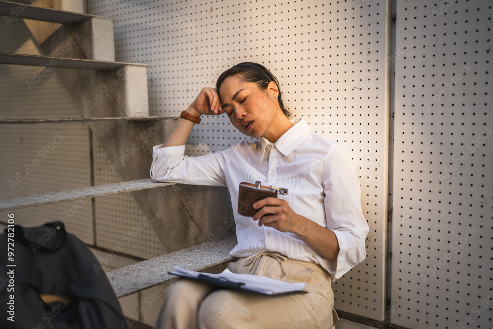mature japanese woman sit outdoor hold flask and drink alcohol