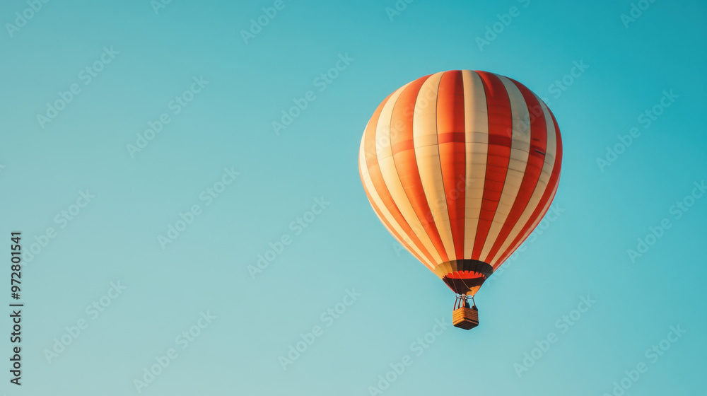 Obraz premium A hot air balloon floating against a clear blue sky, representing freedom and adventure.