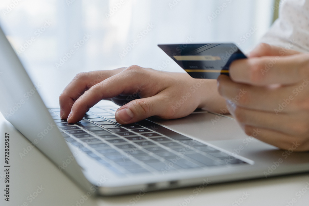 Man using credit card and laptop computer for online payment. Businessman or entrepreneur working from home. Online shopping, e-commerce, and internet banking concept.
