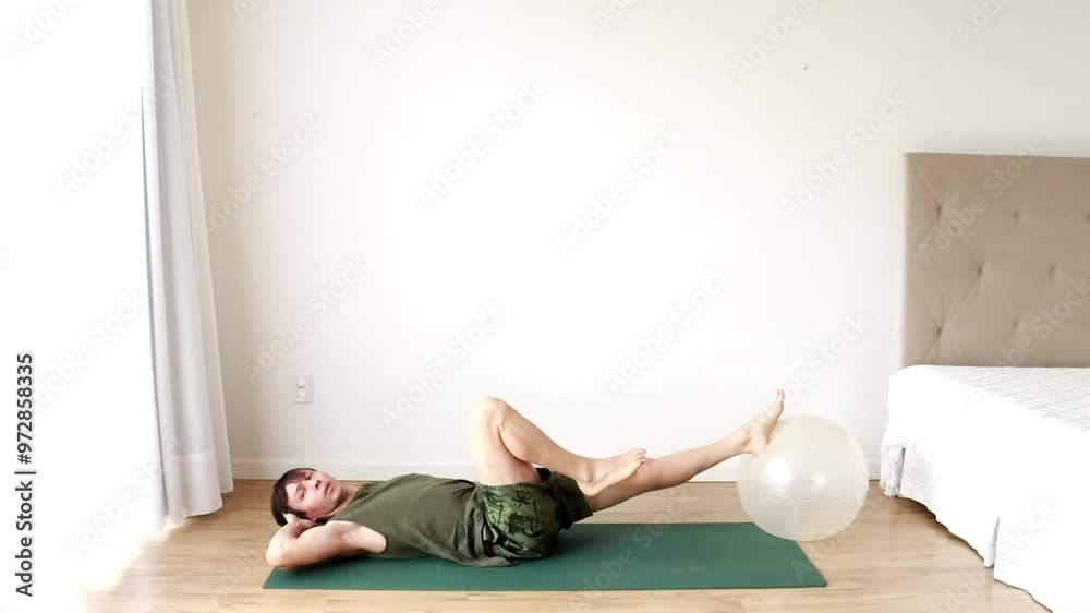 homem faz exercicios fisícos e alongamentos com bola de pilates homem faz exercicios fisícos e alongamentos com bola de pilates