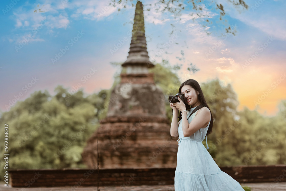 Young woman traveling in the temple at Ayutthaya Historical Park UNESCO World Heritage and taking pictures at the old temple. Young woman traveling in the temple at Ayutthaya Historical Park UNESCO World Heritage and taking pictures at the old temple.