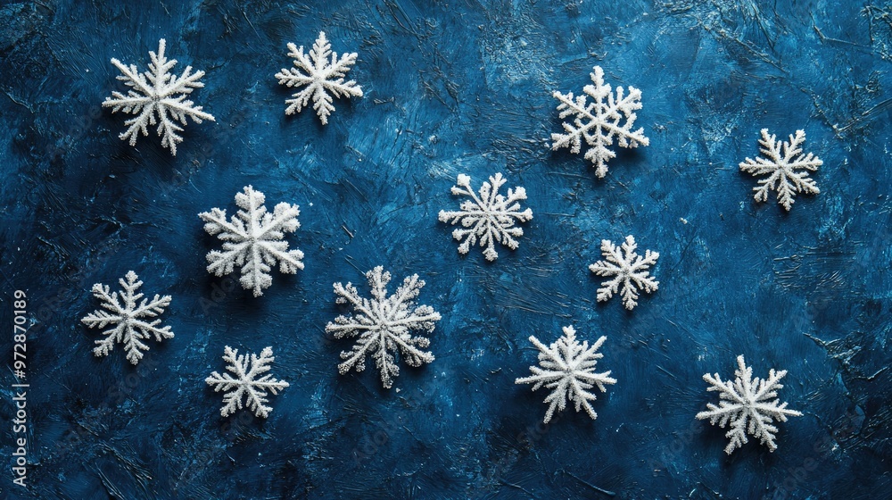 A collection of delicate snowflakes resting on a textured blue background, evoking a sense of icy calm A collection of delicate snowflakes resting on a textured blue background, evoking a sense of icy calm
