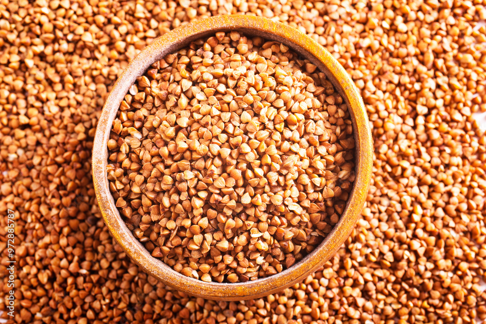 Wooden bowl full of raw wholegrain buckwheat groats Wooden bowl full of raw wholegrain buckwheat groats