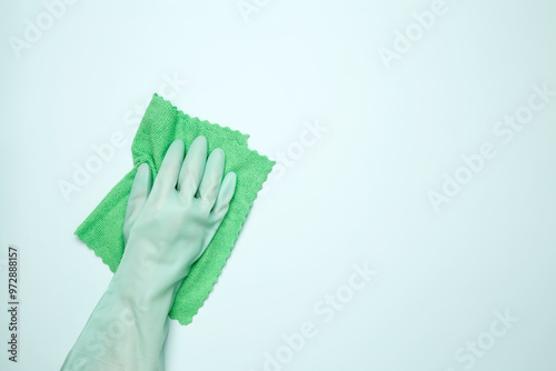 Womans hand in rubber glove holds cloths. House cleaning. Copy space