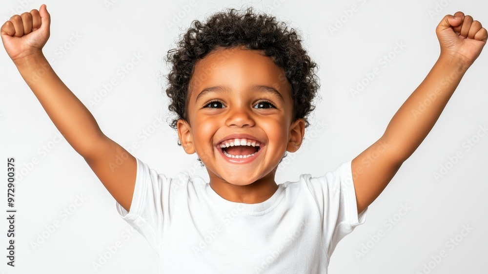 Joyful child with curly hair celebrating happiness with raised arms, radiating positivity and excitement in a bright environment. Joyful child with curly hair celebrating happiness with raised arms, radiating positivity and excitement in a bright environment.