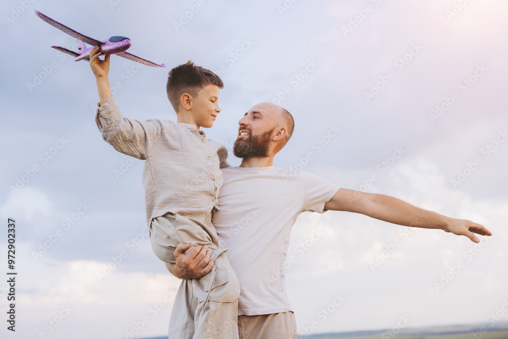 Joyful Father and Son Playing with Toy Airplane in Open Sky Joyful Father and Son Playing with Toy Airplane in Open Sky