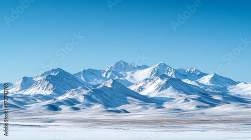 Mongolian mountains in winter, sharp peaks covered in snow, a clear blue sky overhead