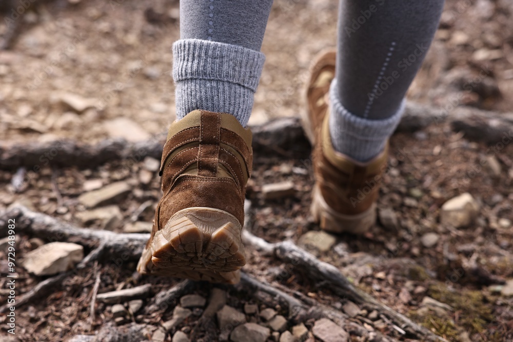 Young hiker in trekking shoes walking outdoors, closeup Young hiker in trekking shoes walking outdoors, closeup