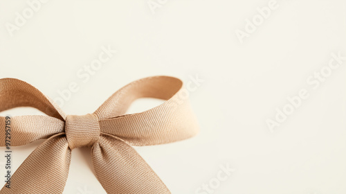 A close-up of a brown bow, illuminated from below, casting a soft glow against a white background, perfect for a celebratory theme. photo