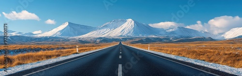 Straight Road Leading to Snowy Mountains Under Clear Blue Skies