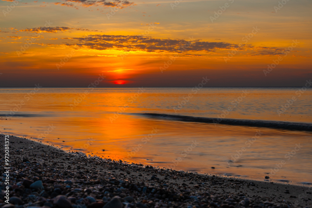 Sandy beach with pebbles of Baltic Sea on Curonian Spit at sunset. Kaliningrad region. Russia
