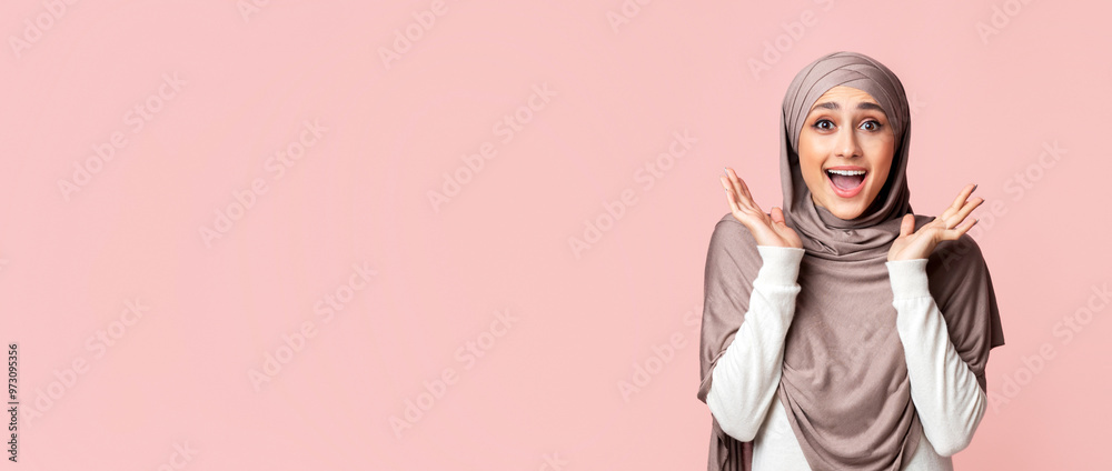Wow. Surprised muslim girl in headscarf opened mouth in amazement over pink studio background, panorama with free space Wow. Surprised muslim girl in headscarf opened mouth in amazement over pink studio background, panorama with free space