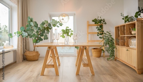 ナチュラルな木製の家具のシンプルでおしゃれな部屋、ユーカリの木をグラスで飾っている