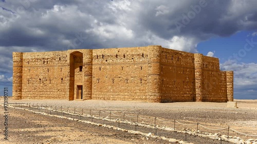 Qasr Kharana (Kharanah or Harrana)-- desert castle in eastern Jordan (100 km of Amman). Built in 8th century AD to be used as caravanserai. Against the sky with clouds. 4K, time lapse  photo