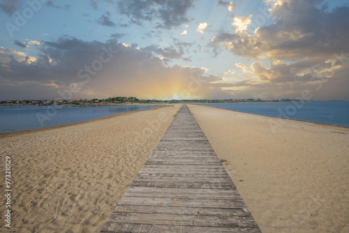 A beach surrounded by the sea on both sides. In the middle a wooden footbridge runs along the sandy beach. Natural spectacle of a Mediterranean landscape, Plaža Ždrijac, Nin, Zadar, Dalmatia, Croatia photo