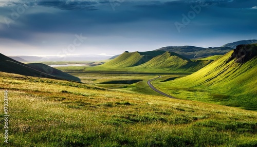 Serene Aerial View of Rolling Green Hills, Meandering River, and Vast Open Landscape Underneath Dramatic Cloudy Skies in a Remote Highland Valley