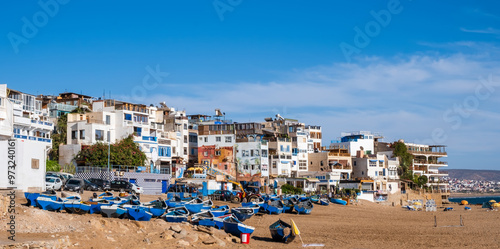 Taghazout, small fishing and surfing village with sandy beach, boats and traditional Moroccan buildings near Agadir, Morocco. Popular seaside resort among surfers