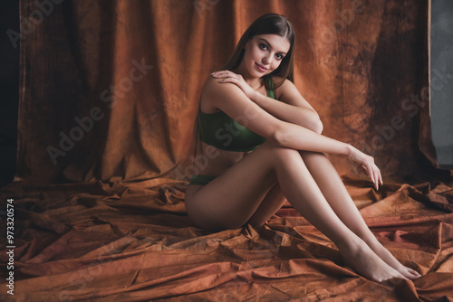 Photo no retouch of gorgeous charming lady wearing trendy sportswear sitting floor isolated on studio brown color background