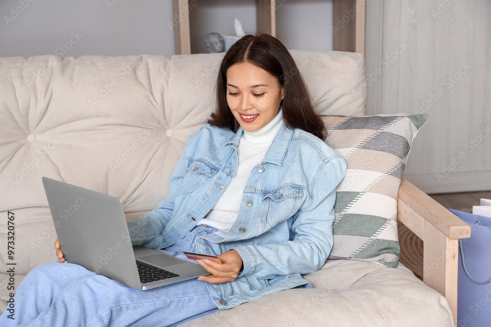 Young Asian woman with laptop shopping online at home Young Asian woman with laptop shopping online at home