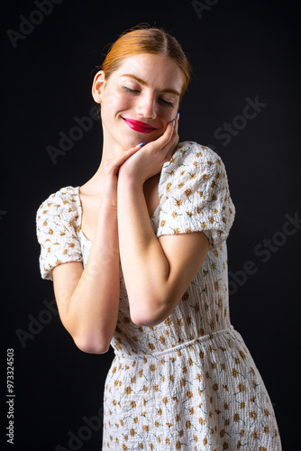 A young redhear girl with clean skin. Beauty portrait of a woman on a black background in the studio. photo