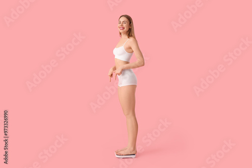 Young woman measuring weigh...