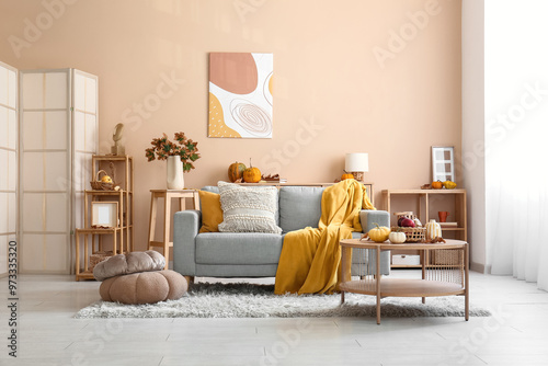 Interior of cozy living room with autumn decor, sofa and table photo