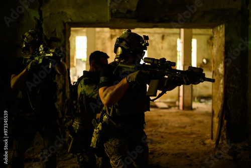 Group of soldiers with rifles in dark room liberating territory. photo