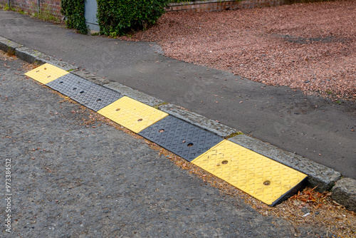 Rubber kerb ramps at end of domestic drive and pavement sidewalk to tarmac road