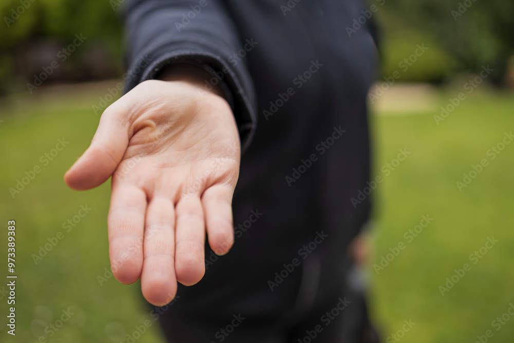 Fototapeta premium Demanding give that concept: Young caucasian woman holding flat hand out to viewer with palm up with blurry background