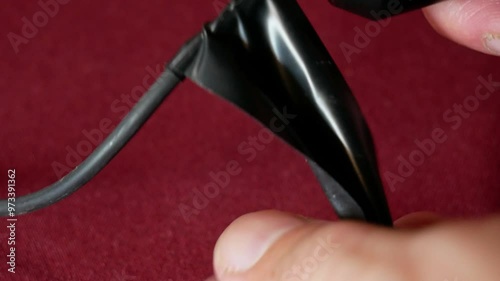 Repairing a microphone with black electrical tape close-up