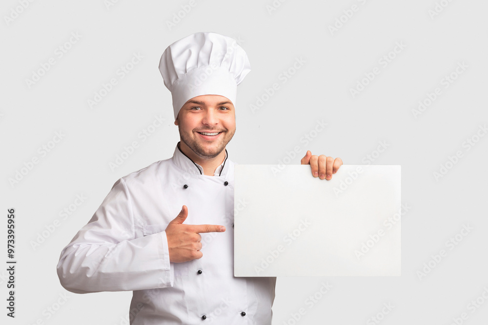 Chef Man Holding Blank White Paper Board Pointing Finger Recommending Best Recipes Standing Over Studio Background. Panorama, Mockup Chef Man Holding Blank White Paper Board Pointing Finger Recommending Best Recipes Standing Over Studio Background. Panorama, Mockup