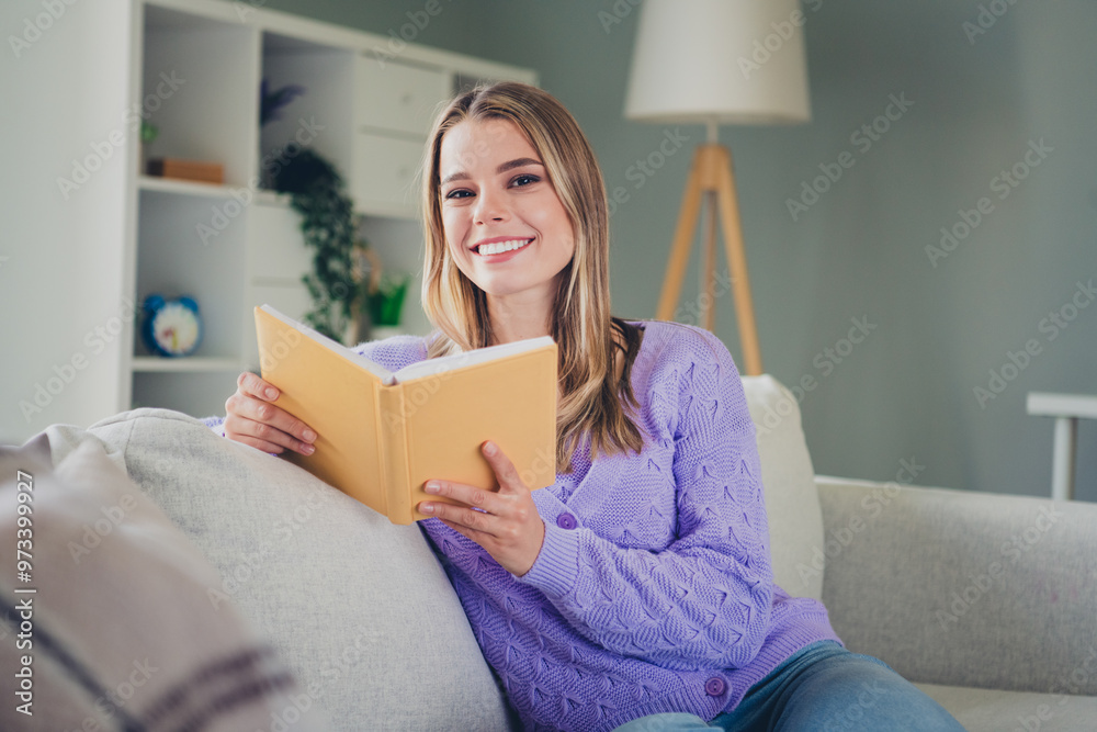 Photo of attractive young woman sit couch reading book dressed purple outfit cozy day light home interior living room Photo of attractive young woman sit couch reading book dressed purple outfit cozy day light home interior living room