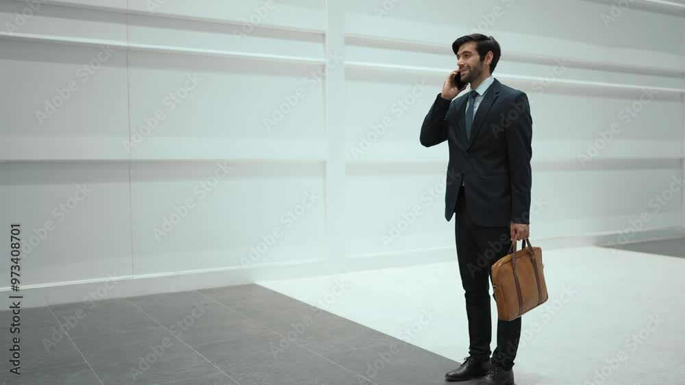Skilled manager using phone call to contact colleague about project. Leader walking while stop to call his business team to report and discuss about sales while standing at white background. Exultant. Skilled manager using phone call to contact colleague about project. Leader walking while stop to call his business team to report and discuss about sales while standing at white background. Exultant.