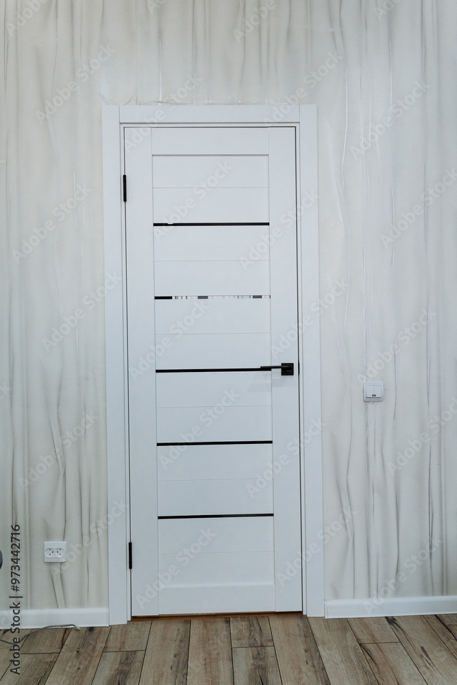A room with a crafted wooden floor and a white door A room with a crafted wooden floor and a white door