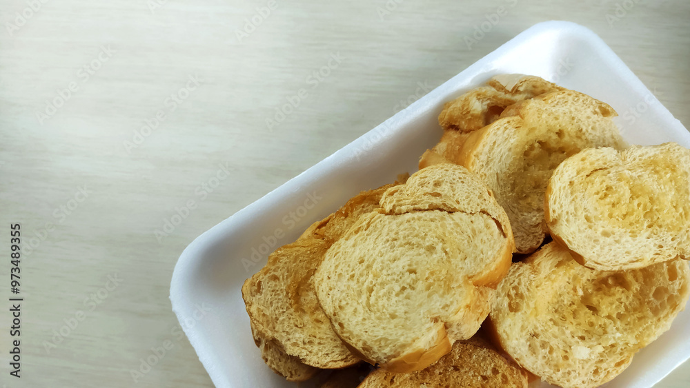 Buttered toasts made of salt french bread on the plate.
Buttered toasts made of salt french bread on the plate.