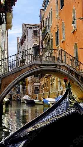A charming Venetian canal showcasing vibrant, colorful buildings and a graceful gondola gliding by channel