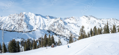 Panoramic photo of Deer Valley, single skier going down, snow covered caps, February 4, 2023