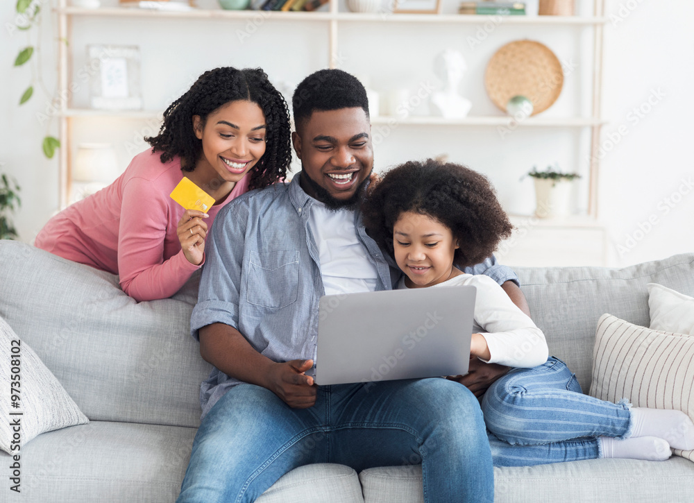 Online Shopping Concept. Happy African American Family With Little Daughter Using Laptop And Credit Card At Home For Buying Goods In Internet Online Shopping Concept. Happy African American Family With Little Daughter Using Laptop And Credit Card At Home For Buying Goods In Internet