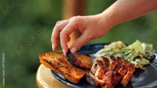 women's hand putting meat into a sandwich, grilled meat and bread and  