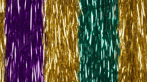 shimmering straight tinsel garland curtain texture featuring distinct vertical stripes of purple, gold and greenan extreme close-up of reflective fibers photo