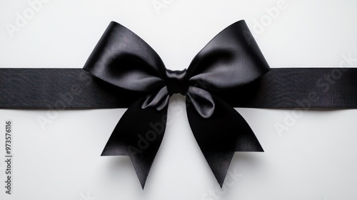 Black satin ribbon tied in a bow on a white background.