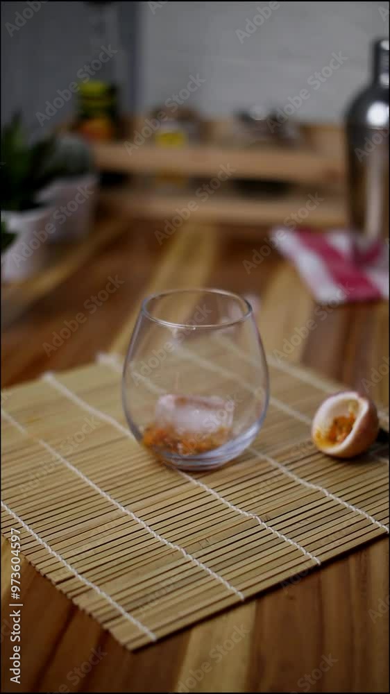 put ice into a glass containing passion fruit. vertical video put ice into a glass containing passion fruit. vertical video