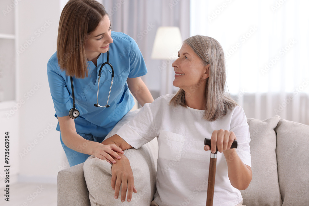 Young healthcare worker supporting senior patient indoors Young healthcare worker supporting senior patient indoors