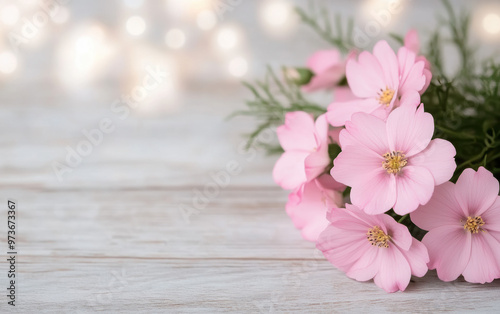 Elegant bouquet of pink flowers with green leaves on a wooden surface against a bokeh background, perfect for nature, floral, and romantic themes.